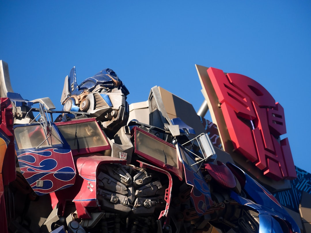 Robotic figure with blue and red details against sky