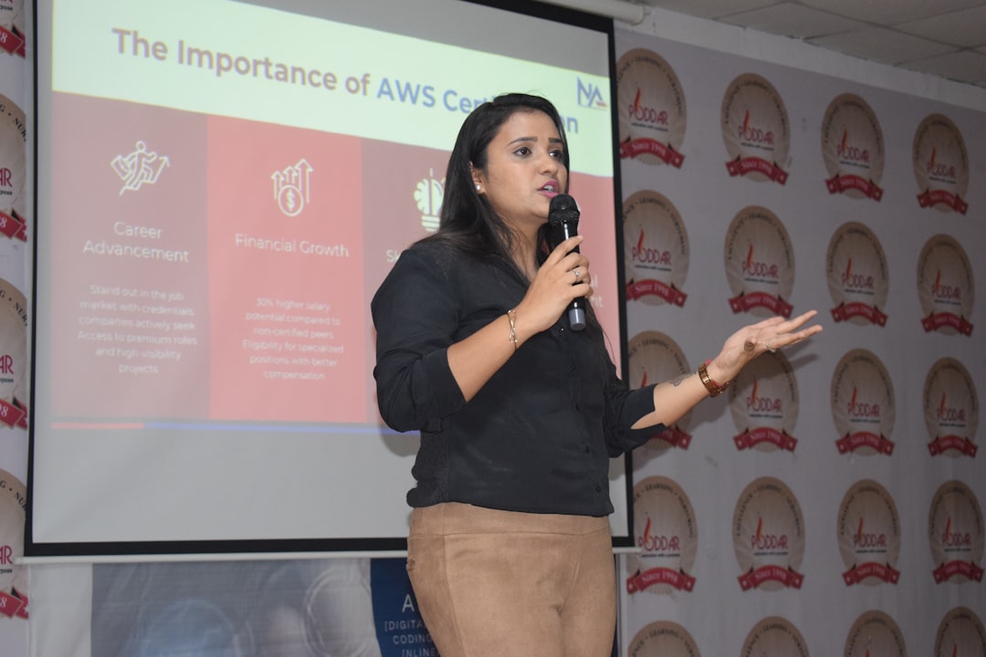 Female speaker presenting in front of a projector screen.