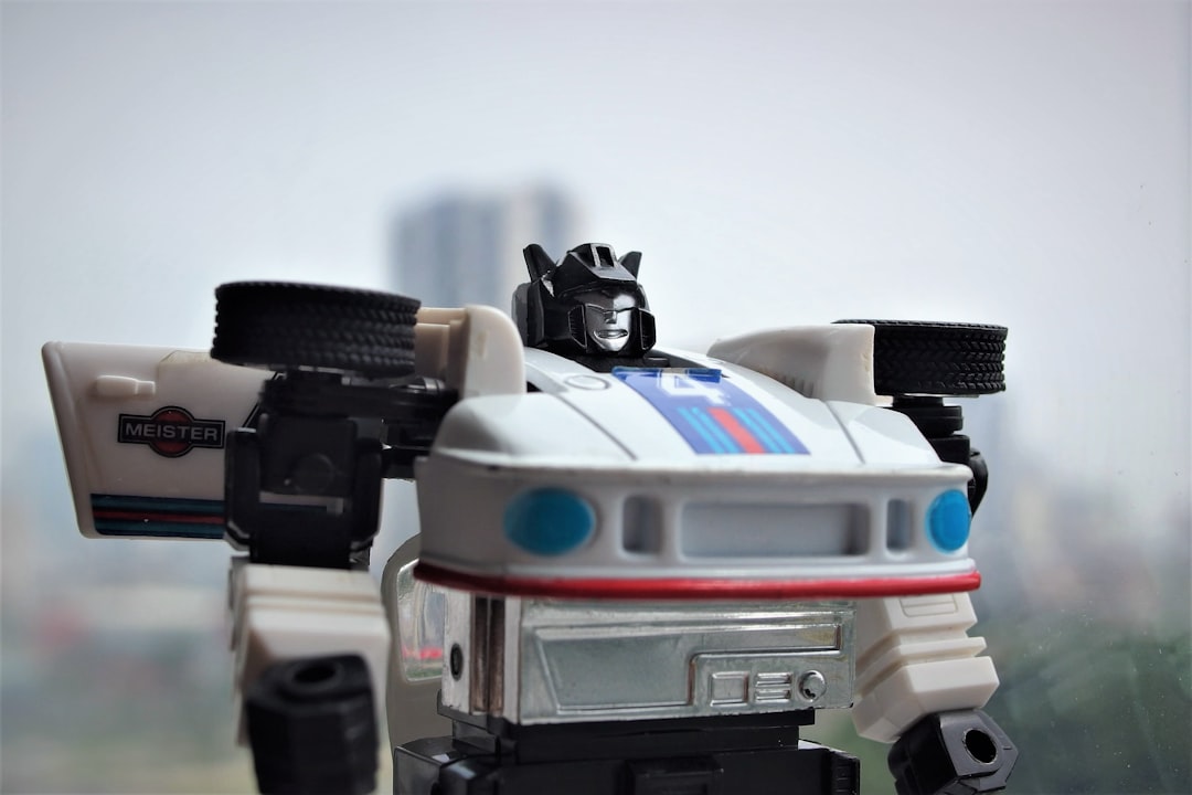 A white robot car toy with blue and red stripes