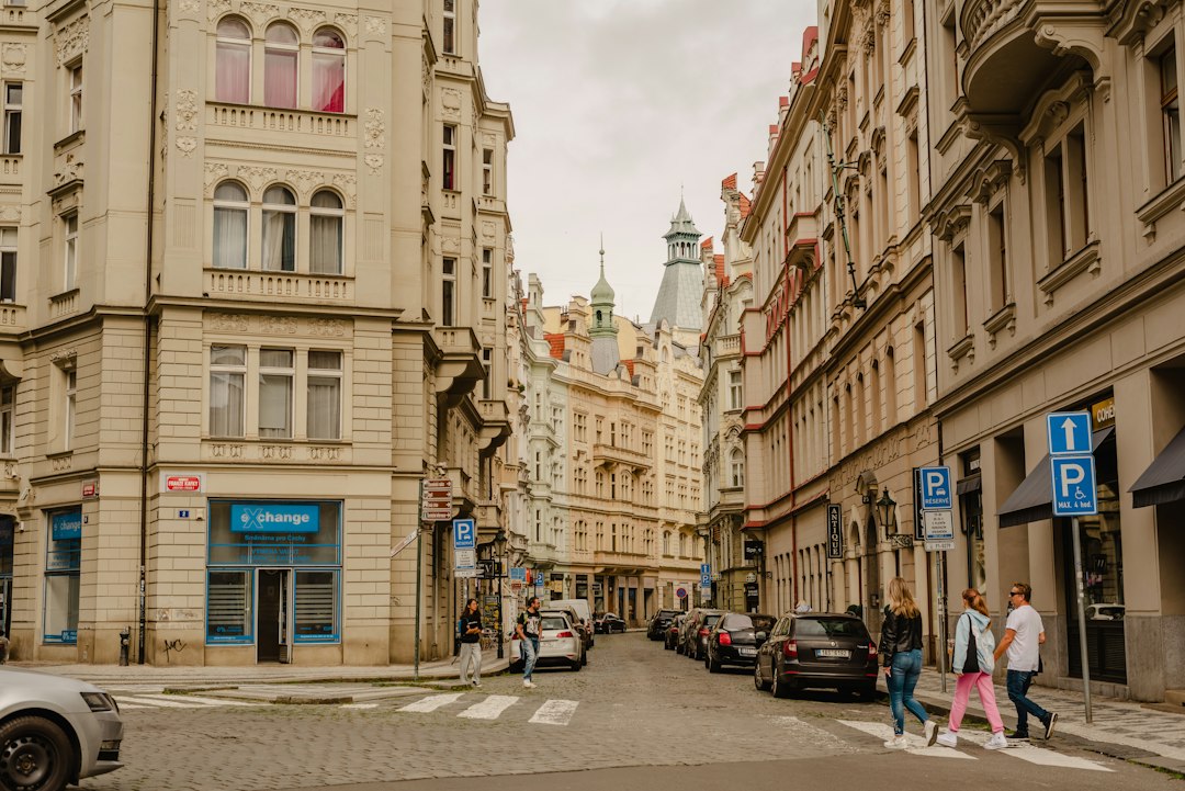 a group of people walking down a street next to tall buildings