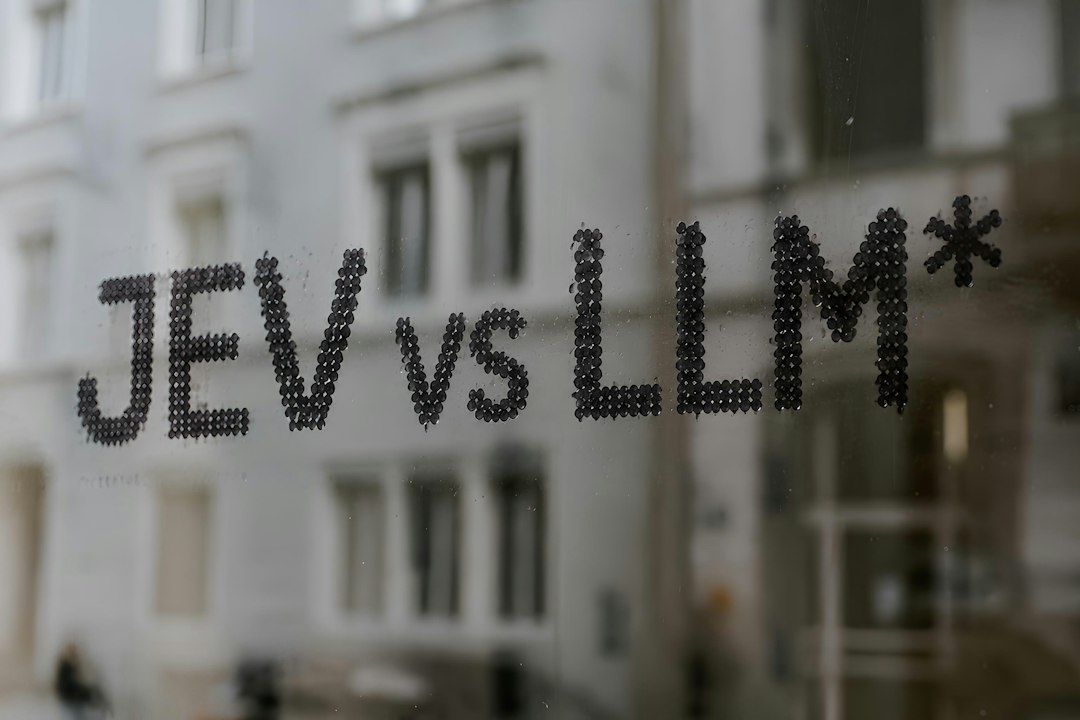 The text JEV VS LLM* written in black dots on a glass window